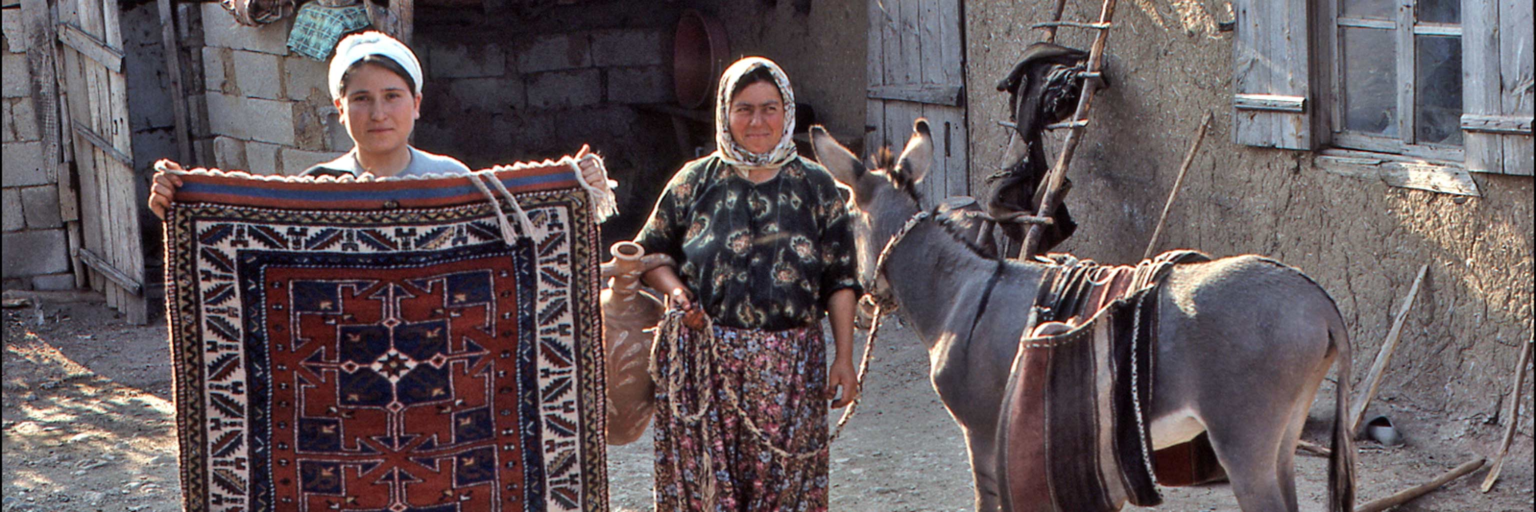 Woman presenting a woven wool rug.