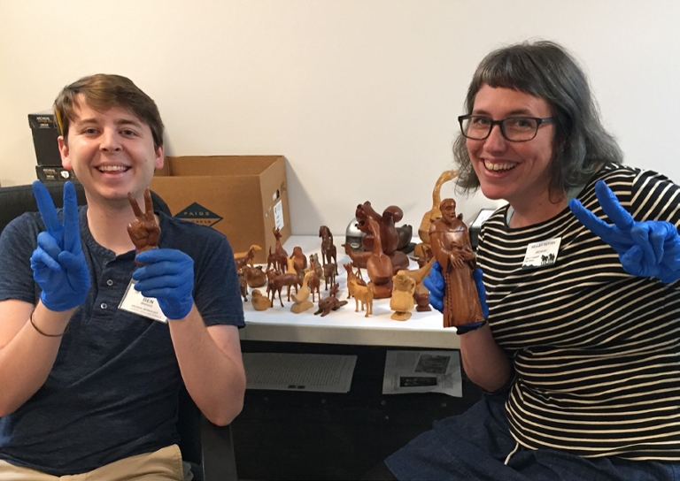 Ben Bridges and Kelly Totten holding up wood figurines.
